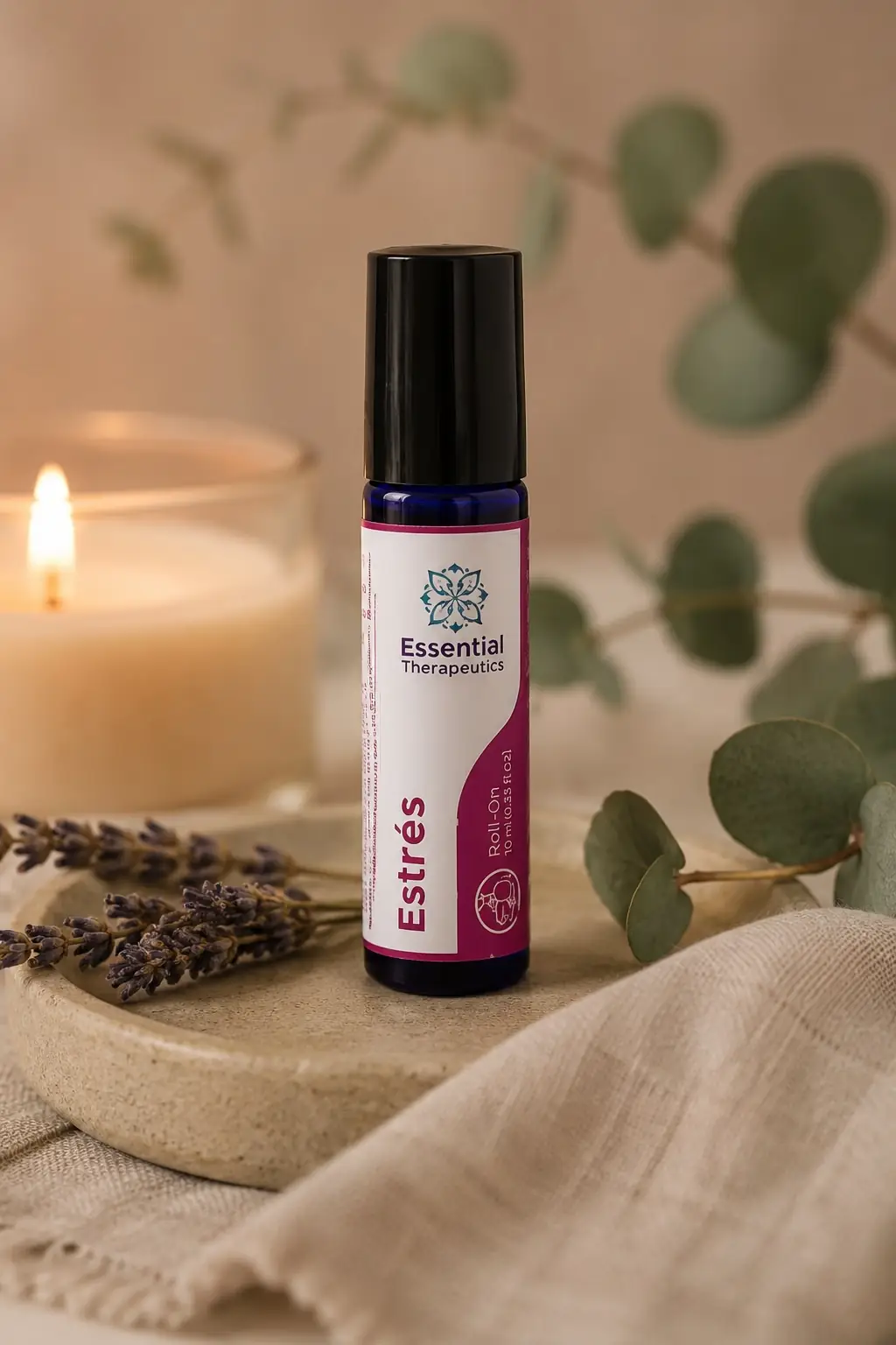 Roll-On Estrés de Essential Therapeutics sobre una bandeja de piedra con lavanda, eucalipto y una vela en un ambiente cálido de bienestar.