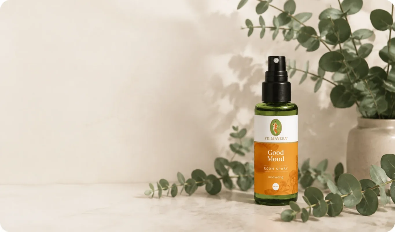 Brisa aromática Primavera Good Mood en spray para ambientes sobre una superficie natural con hojas verdes