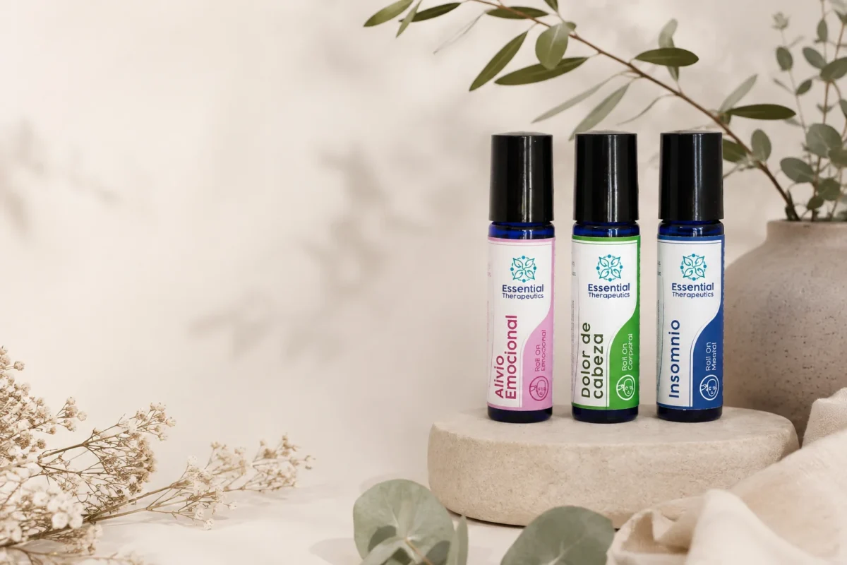 Tres roll-ons Essential Therapeutics de aromaterapia para emociones, dolor de cabeza e insomnio en una escena natural minimalista